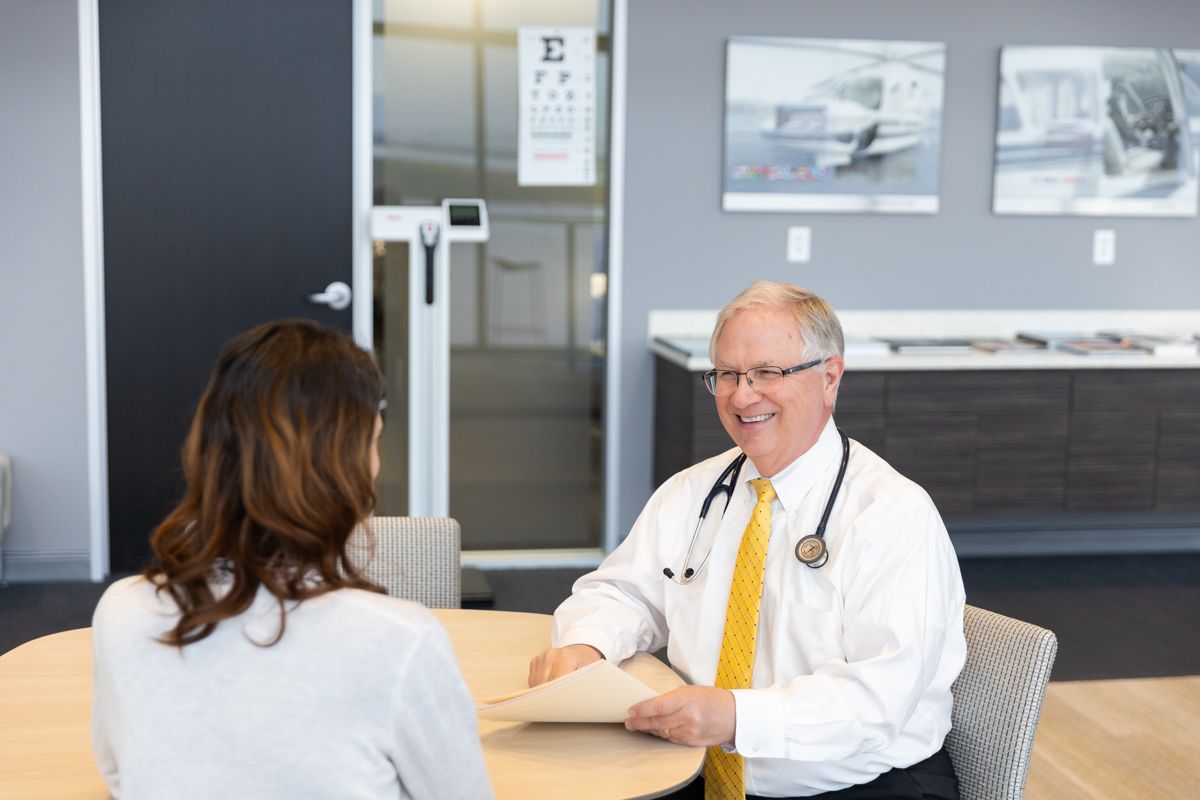 Dr. Edmondson reviewing FAA medical certificate paperwork with a pilot in his exam room