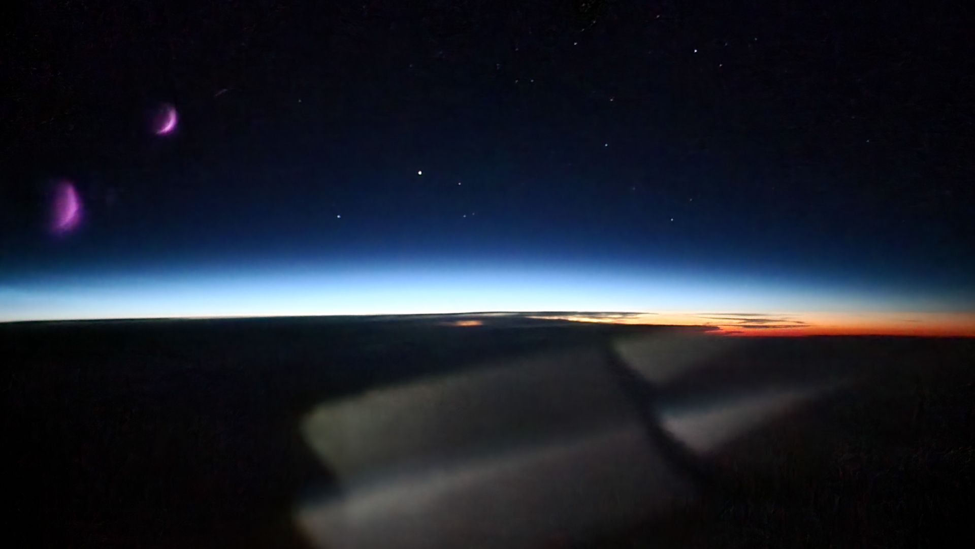 Aurora over the night sky seen from the flight deck