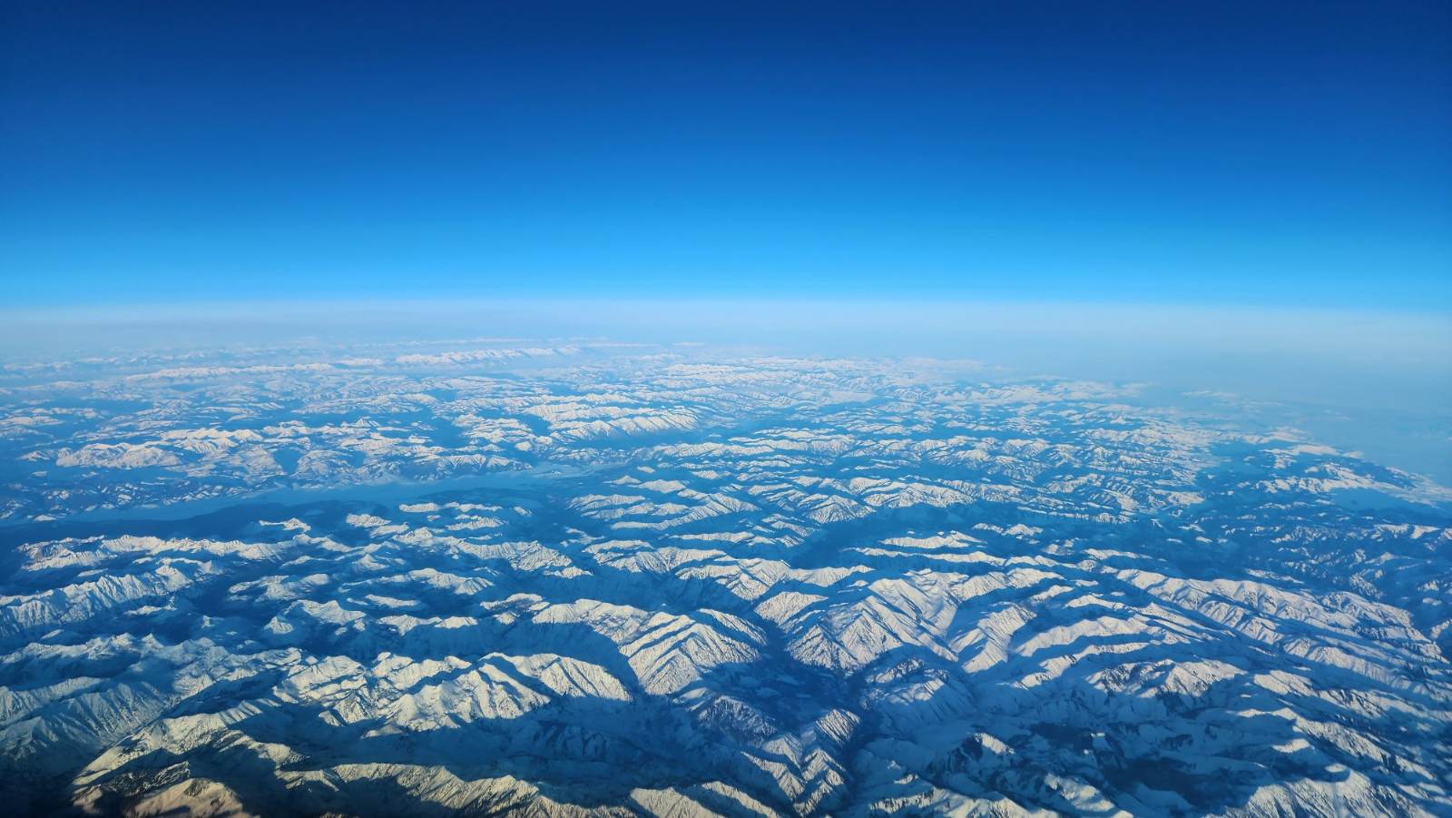 Snow-capped mountain ranges seen from cruise altitude